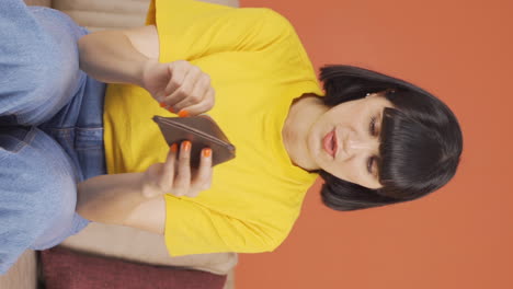 Vertical-video-of-Penniless-young-woman-looking-at-her-empty-wallet.